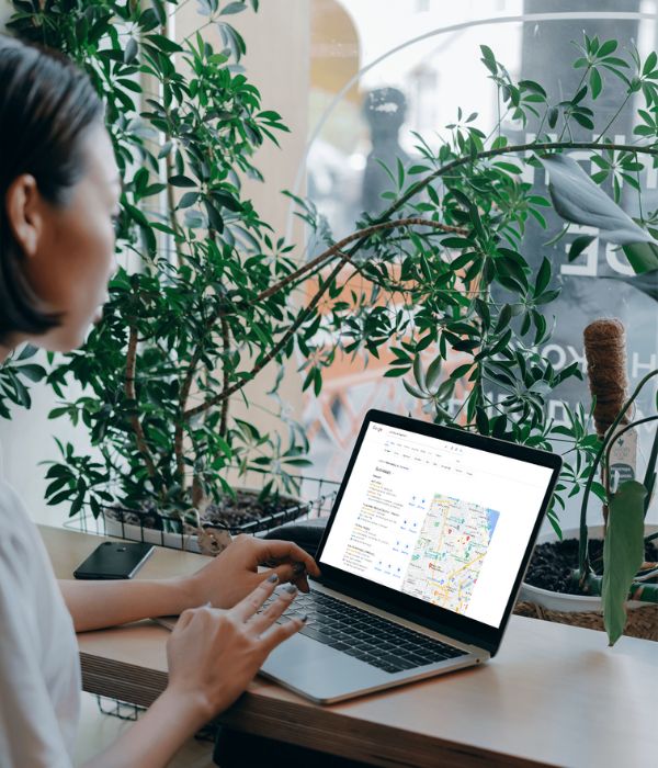 Woman sitting at desk looking at laptop with local business listings
