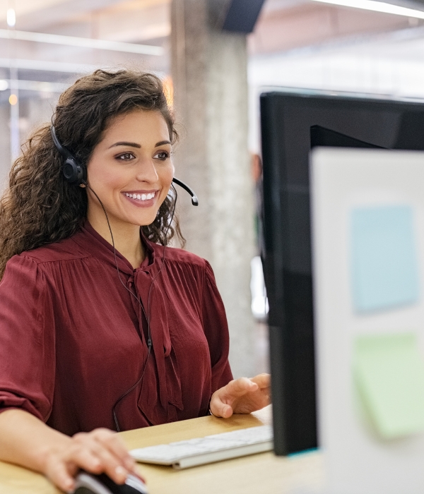 Woman with headset looking at computer