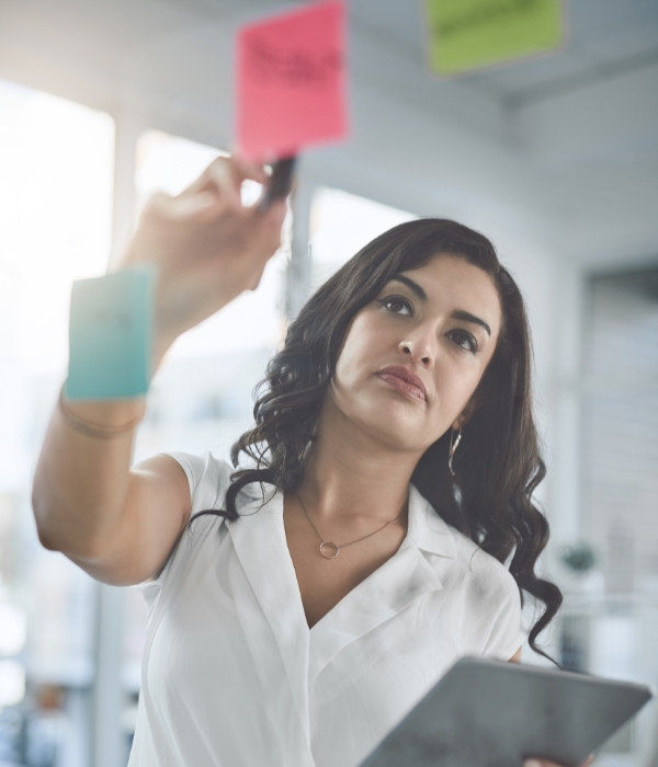 Woman pointing to sticky notes on a wall