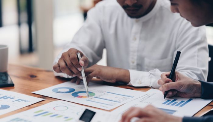 Two people looking at printed reports with pie charts