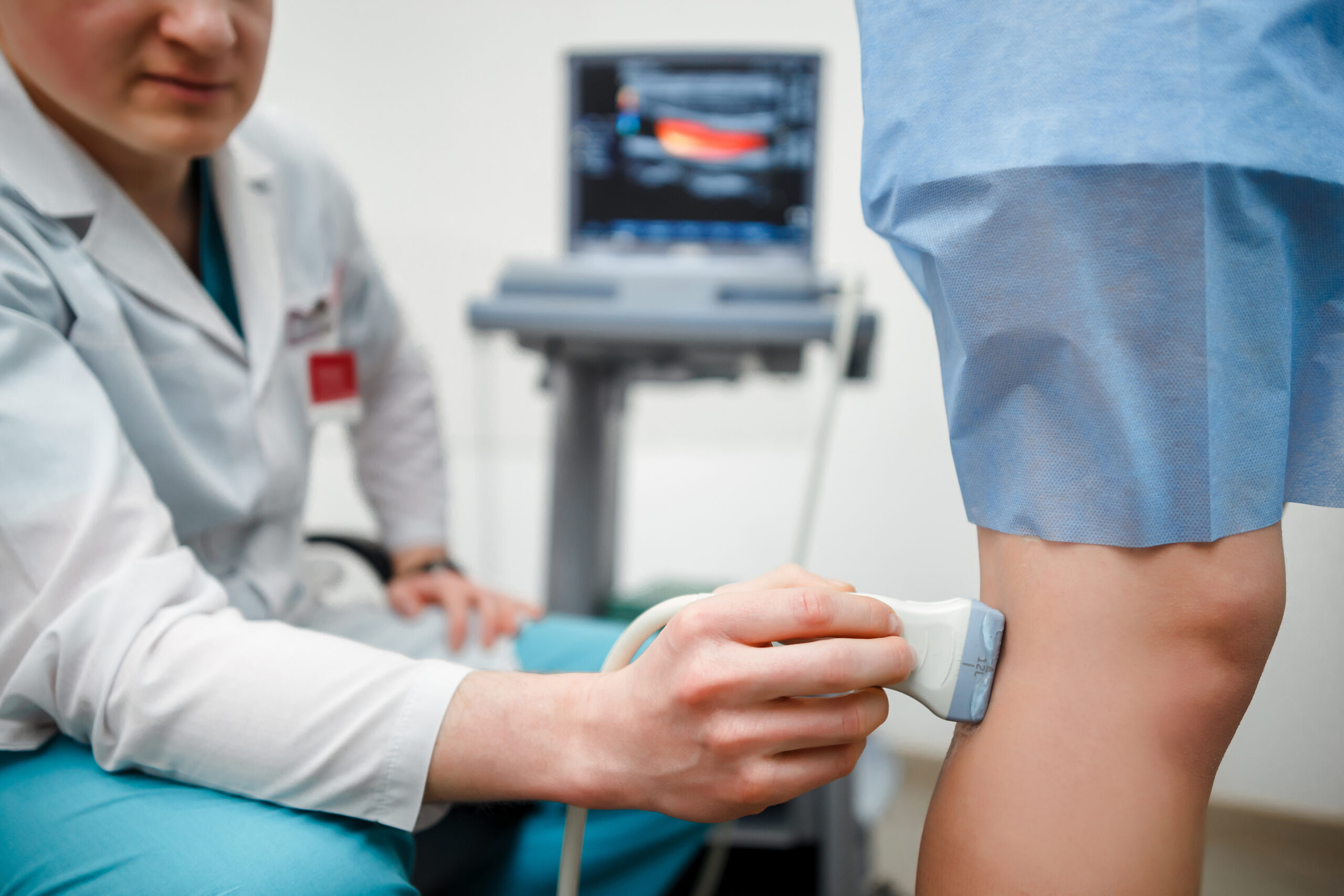 Vein doctor using ultrasound on patient leg