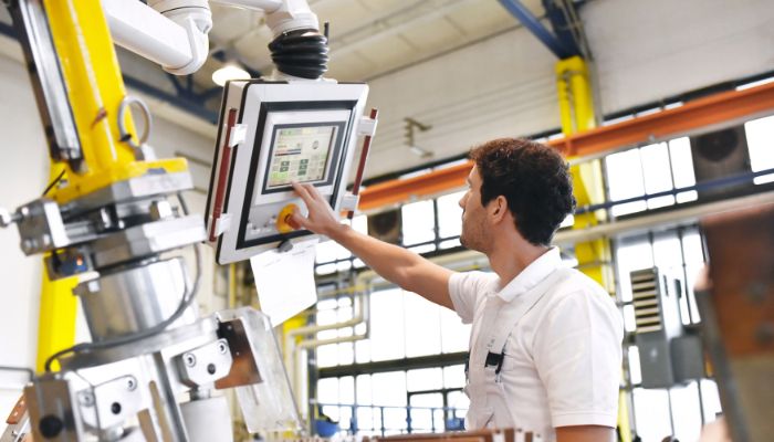 Man working with a machine in manufacturing plant