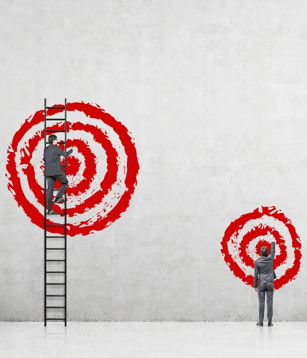 Image of two targets drawn on a wall, one large target with a person on a ladder in front of it and one small target with a person standing in front of it